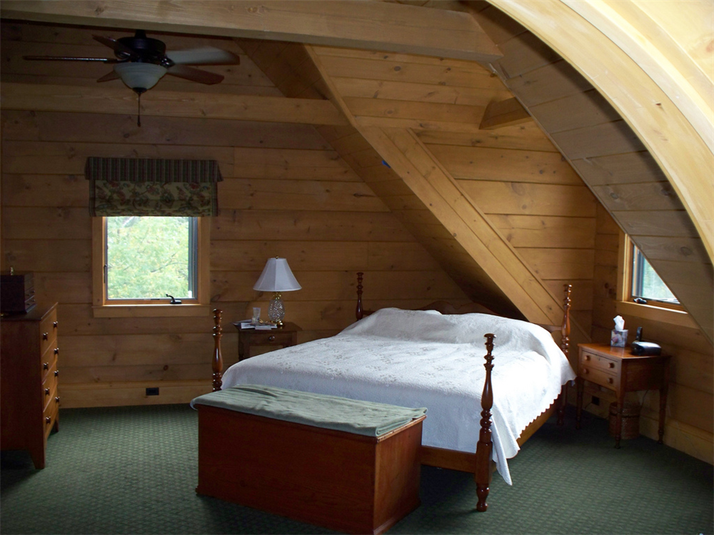 The pine walls in this bedroom give it a very inviting rustic appearance.