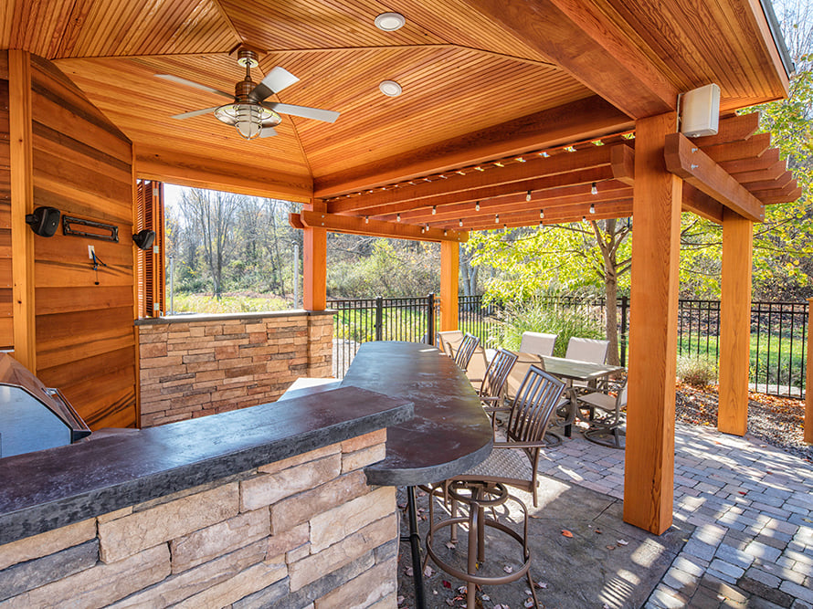 Outdoor entertainment space with seating, kitchen, recess lighting, and ceiling fan
