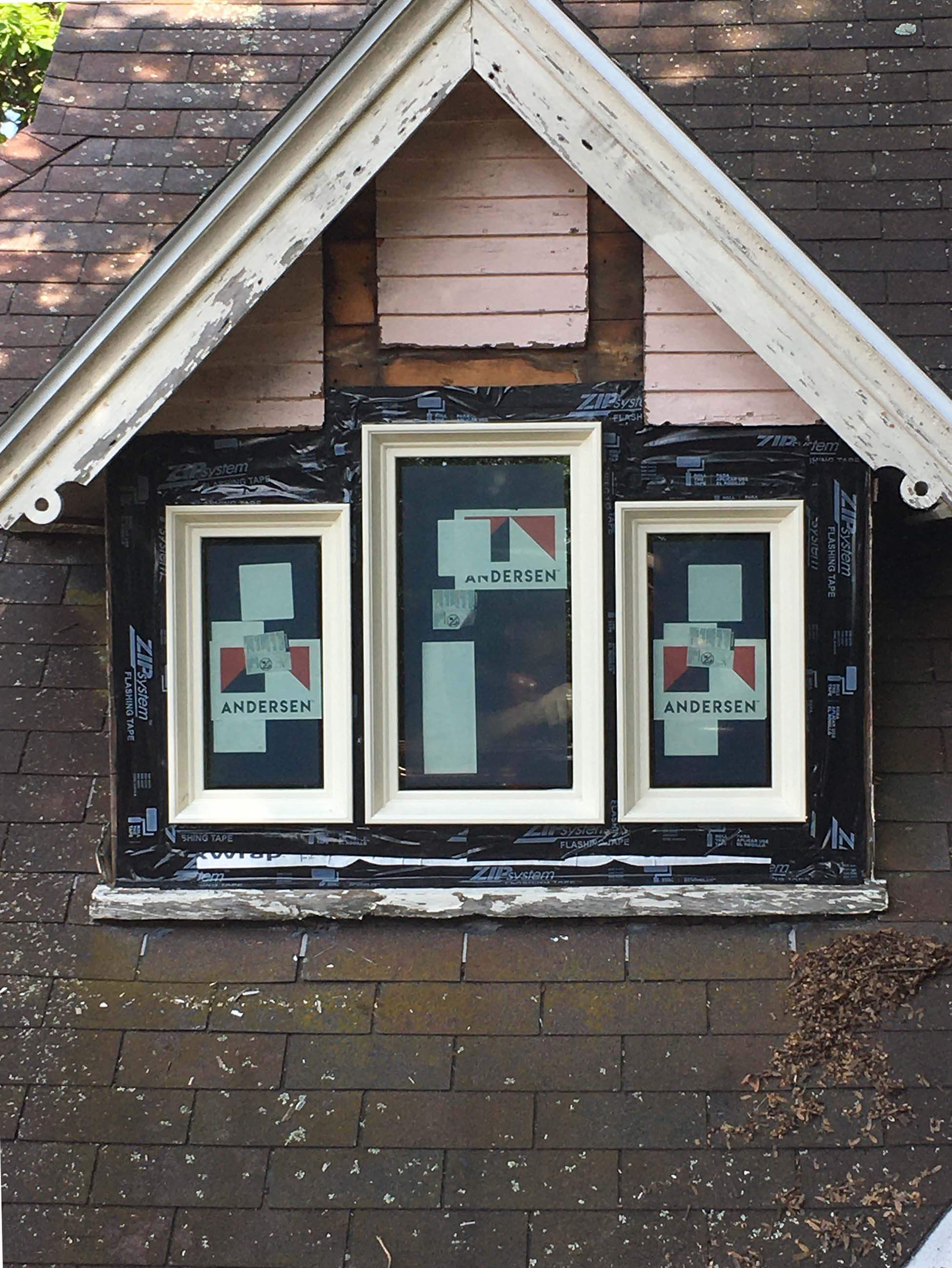 Installation of new custom Andersen windows in a gable dormer on a historic Fayetteville, NY home. Image shows three-unit window set with flashing tape applied, part of McClurg Remodeling’s certified Andersen window replacement project.
