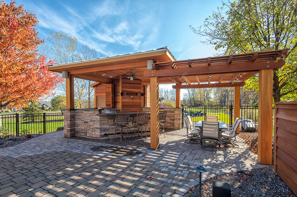 An outdoor entertaining space with a cooking area, a bar area, and a dining area.