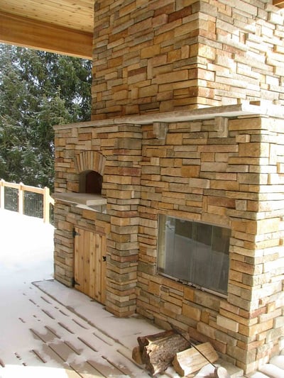 outdoor fireplace and pizza over with manufactured stone veneer