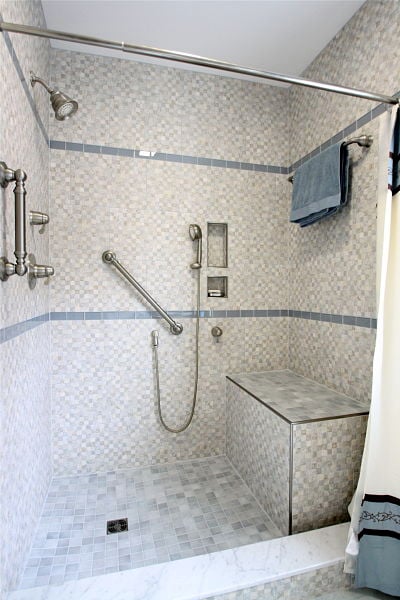 walk-in shower with grab bars and bench seat