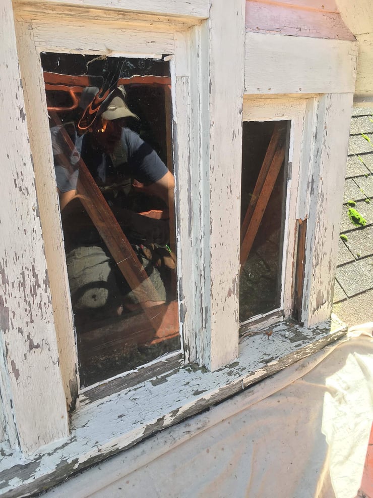 Close-up of deteriorating wood windows on a historic Fayetteville, NY home before restoration. Shows chipped paint, wood rot, and original trim prior to custom Andersen window replacement by McClurg Remodeling.