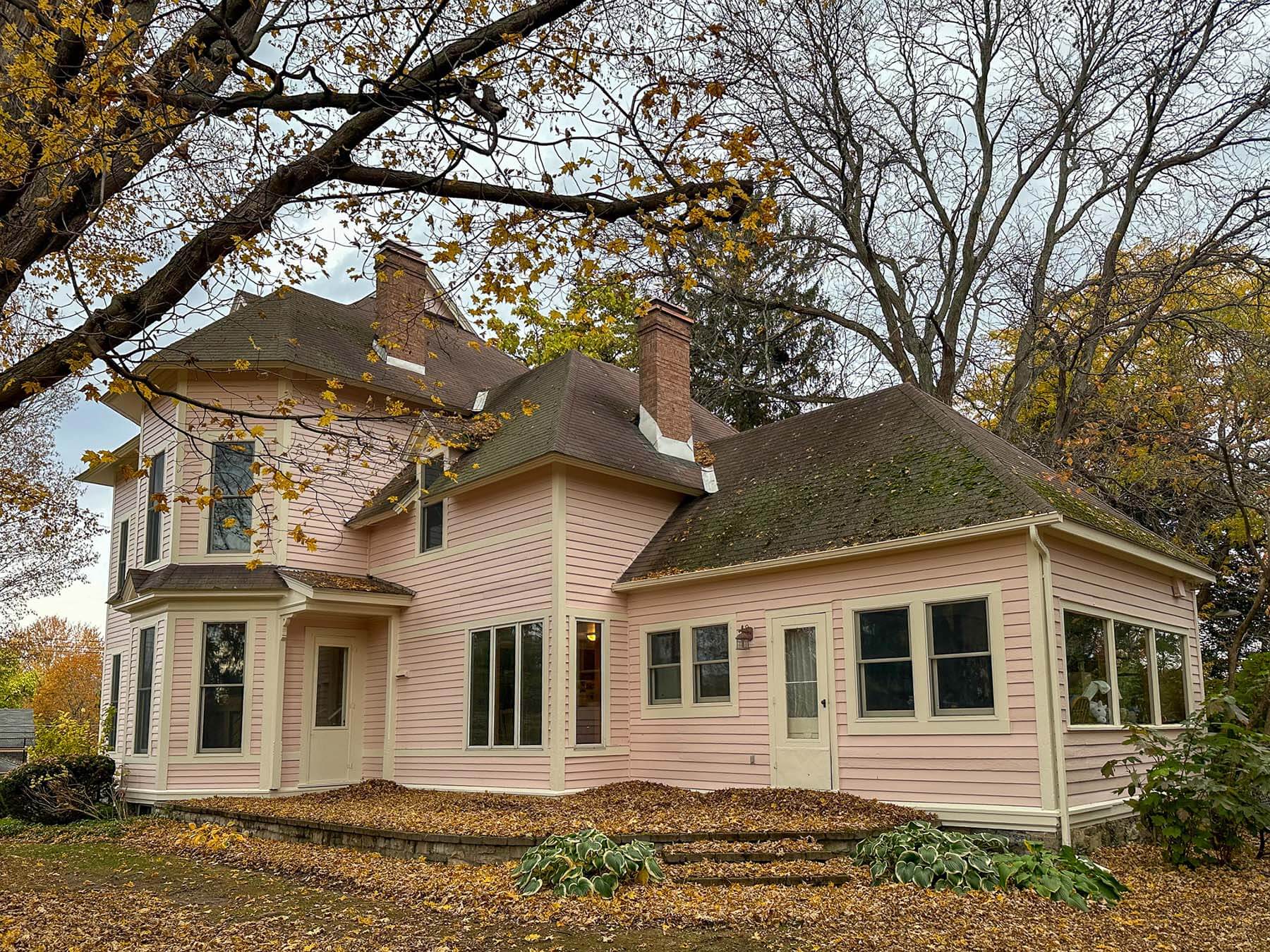 Side and rear view of a historic Victorian home in Fayetteville, NY after full window replacement by McClurg Remodeling. Features custom Andersen windows installed to match original architecture and improve energy efficiency.