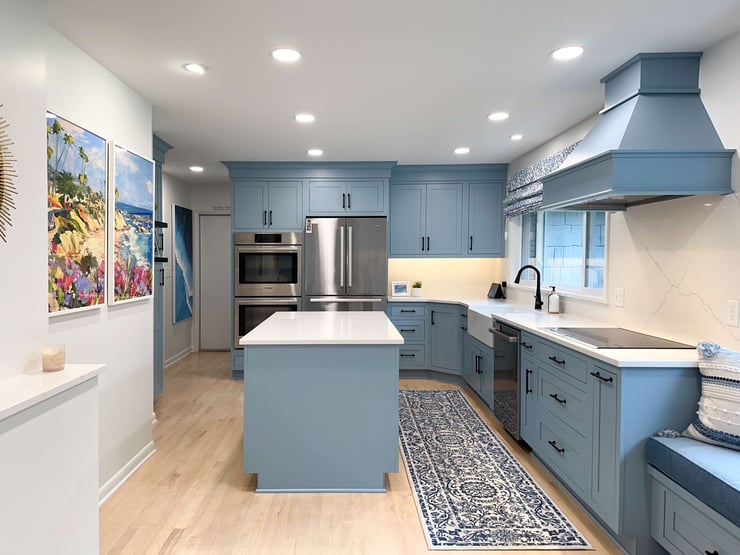 Custom remodeled kitchen with integrated lighting design, combining ceiling-mounted recessed lights, under-cabinet lighting, and daylight from window over the sink.