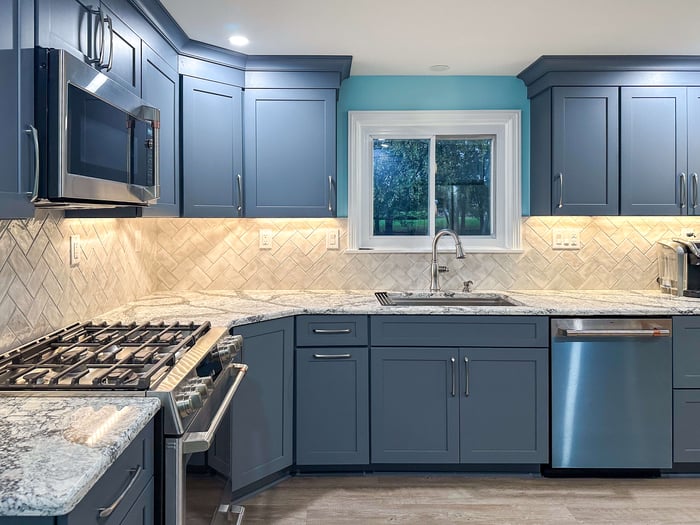 Kitchen lighting design combining under-cabinet LEDs and natural daylight, enhancing visibility across granite countertops and tile walls.