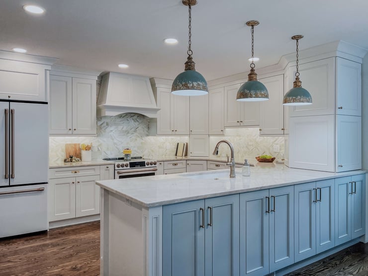 Bright and functional kitchen lighting plan with three industrial pendants, overhead recessed lights, and soft under-cabinet glow highlighting unique tile backsplash.