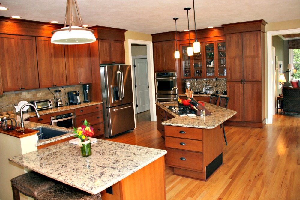 The variation of counter height is intentional and subtle in this universal design kitchen. Toe kicks provide barrier-free access to storage drawers and cabinets. The island is the primary work area in the kitchen. It contains the cooktop, a prep sink, pullout drawers for storage of cookware and utensils and an ample counter for food prep and informal dining.