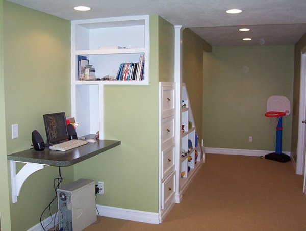Cubbies and drawers were custom built underneath the stairs to this finished basement to create a place for toys and books to be neatly stored. A small countertop was installed to create a computer station.