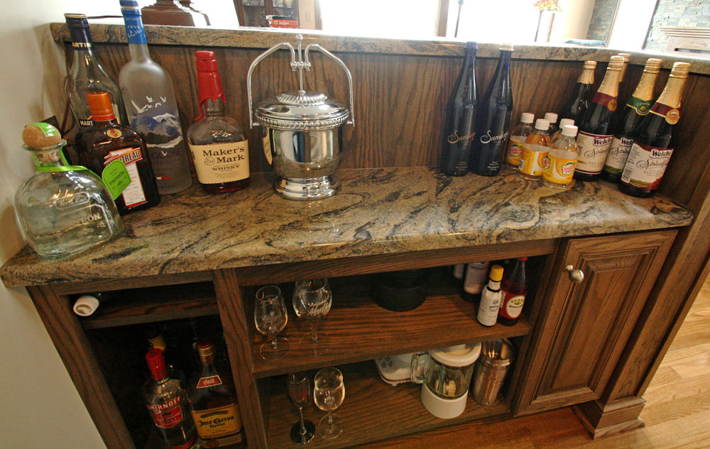 Bar storage area with granite shelf and counter. Oak cabinet is from Bishop Cabinets.