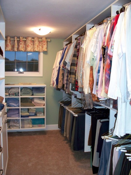This walk-in closet combined closet rods, drawers and shelves to create storage space for all types of clothing and accessories.